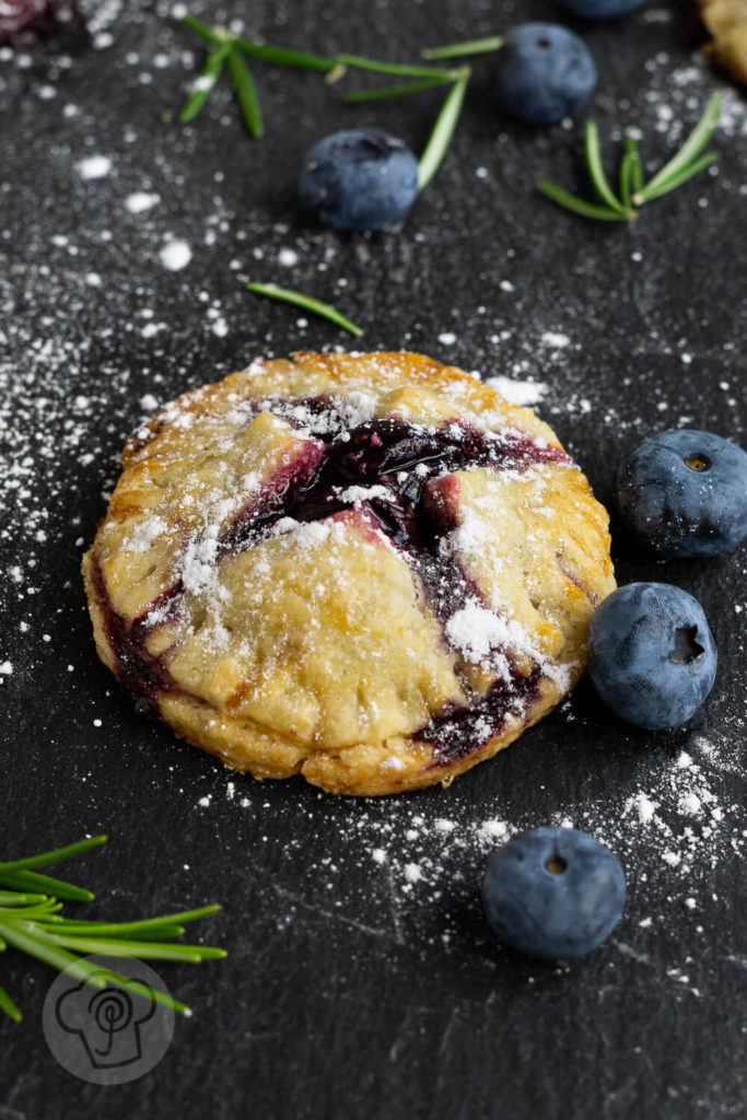 Leckere Handpies mit Blaubeeren und Rosmarin. Ein herrlich fruchtiger, sommerlicher Snack für das Picknick oder einfach so zum Naschen. Küchentraum & Purzelbaum | #blaubeeren | #heidelbeeren | #mürbteig