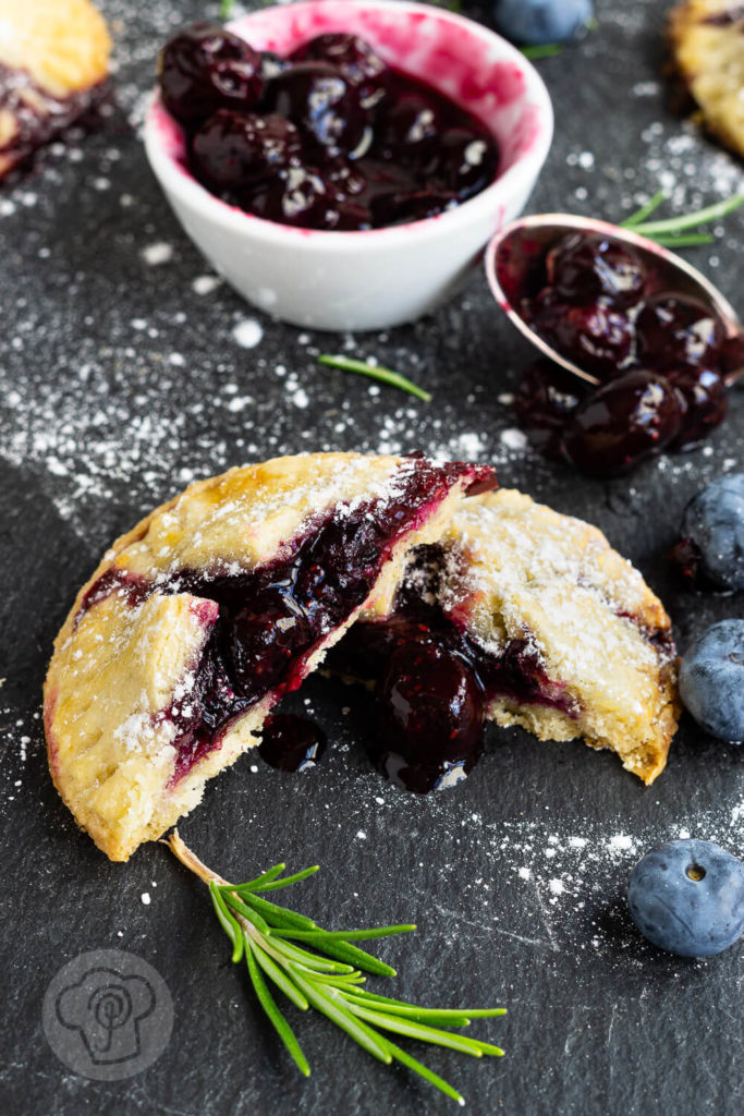 Leckere Handpies mit Blaubeeren und Rosmarin. Ein herrlich fruchtiger, sommerlicher Snack für das Picknick oder einfach so zum Naschen. Küchentraum & Purzelbaum | #blaubeeren | #heidelbeeren | #mürbteig