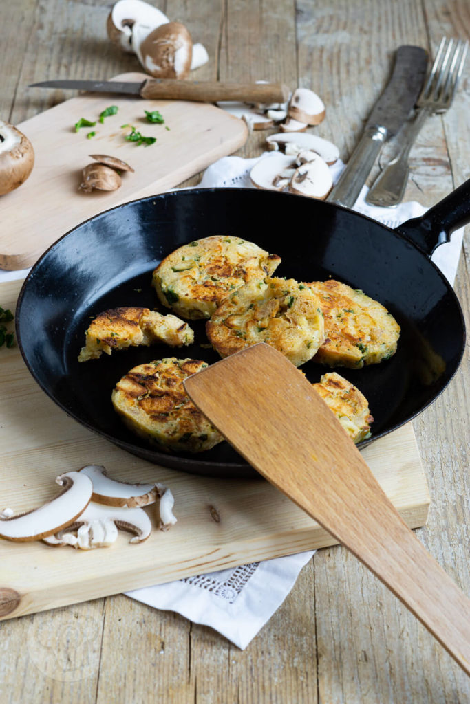 Serviettenknödel mit Pilzsoße und frischen Kräutern. Serviert in einer Pfanne.