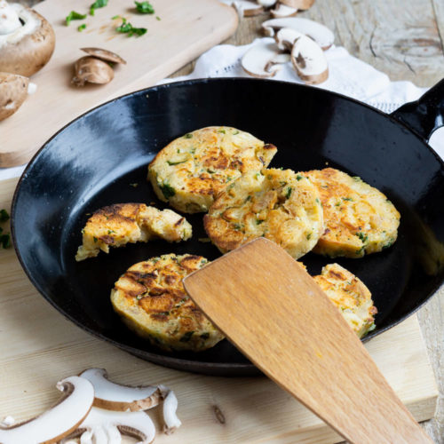 Serviettenknödel mit Pilzsoße und frischen Kräutern. Serviert in einer Pfanne.