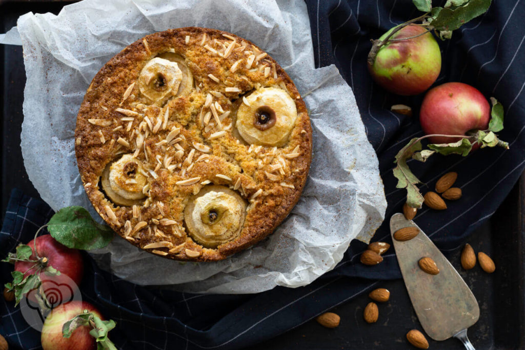 Bratapfelkuchen mit Äpfeln und Mandeln dekoriert