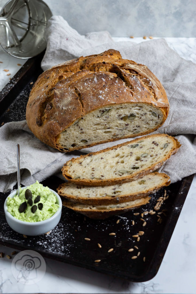 Dinkel Joghurt Brot mit Leinsamen und Kürbiskernen. Angeschnitten mit Aufstrich.