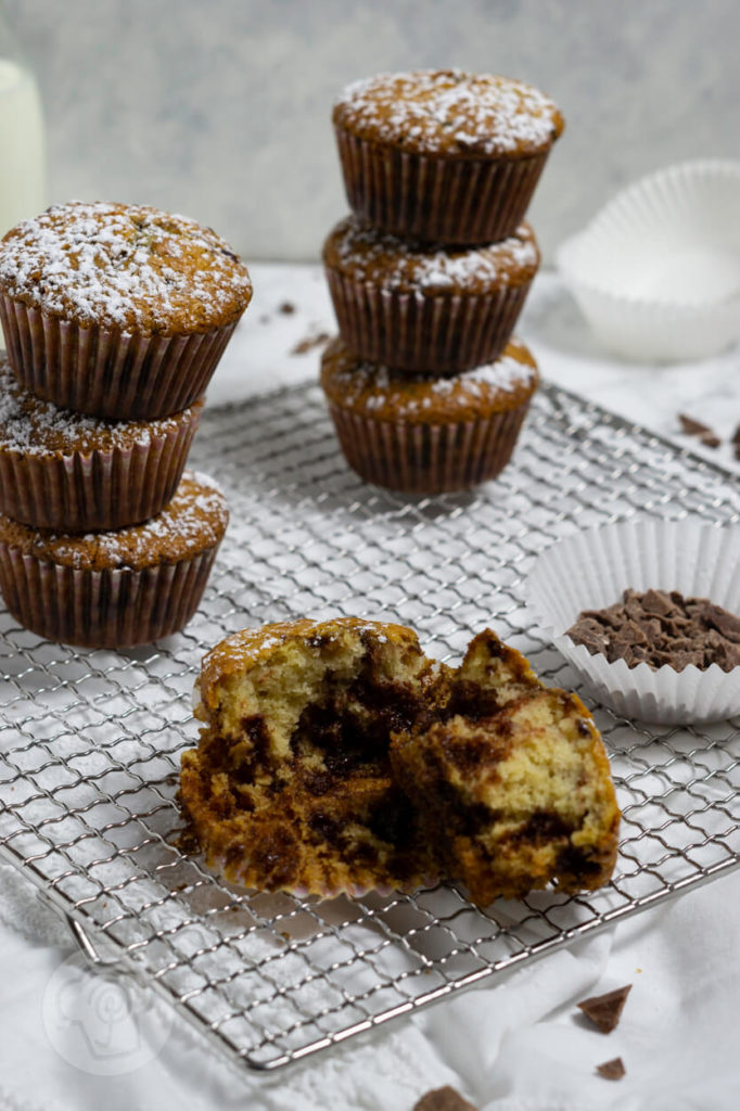 Muffins mit Schokostückchen gestapelt. Ein Muffin auseinander gebrochen.