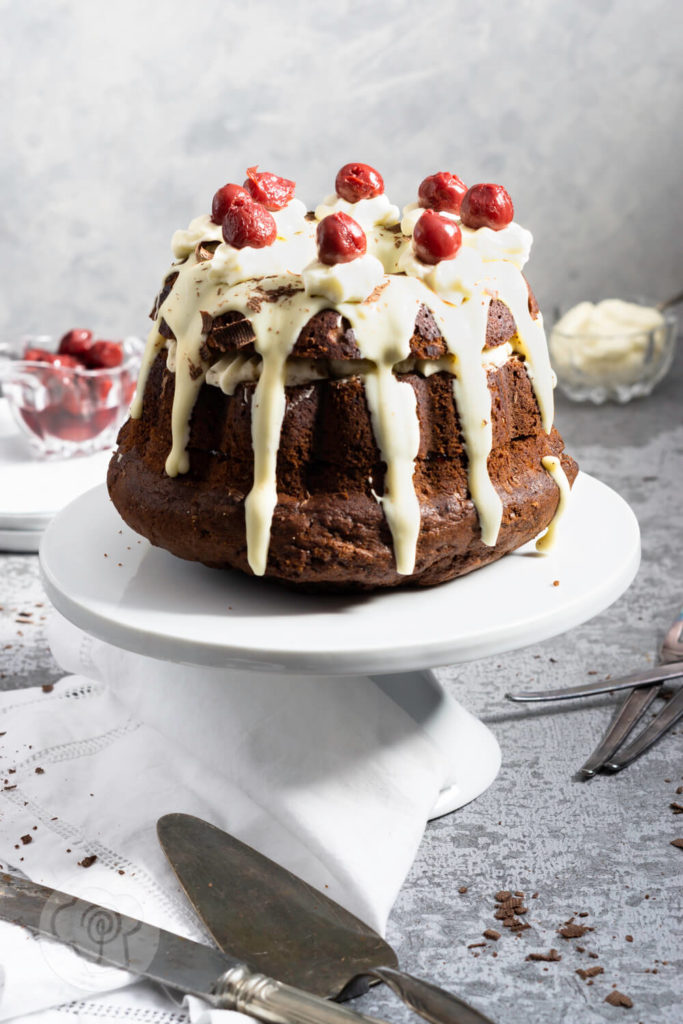 Rezept zum Backen. Schwarzwälder Kirsch Gugelhupf. Eine Neuinterpretation der klasischen Schwarzwälder Kirsch Torte. Probiert doch diesen einfachen und leckeren Kuchen mit Kirschen und weißer Schokoglasur einfach aus. Küchentraum & Purzelbaum