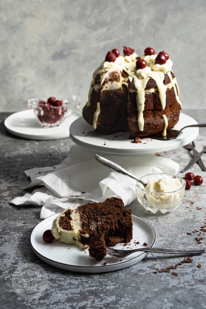 Rezept zum Backen. Schwarzwälder Kirsch Gugelhupf. Eine Neuinterpretation der klasischen Schwarzwälder Kirsch Torte. Probiert doch diesen einfachen und leckeren Kuchen mit Kirschen und weißer Schokoglasur einfach aus. Küchentraum & Purzelbaum