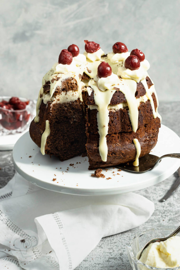 Rezept zum Backen. Schwarzwälder Kirsch Gugelhupf. Eine Neuinterpretation der klasischen Schwarzwälder Kirsch Torte. Probiert doch diesen einfachen und leckeren Kuchen mit Kirschen und weißer Schokoglasur einfach aus. Küchentraum & Purzelbaum