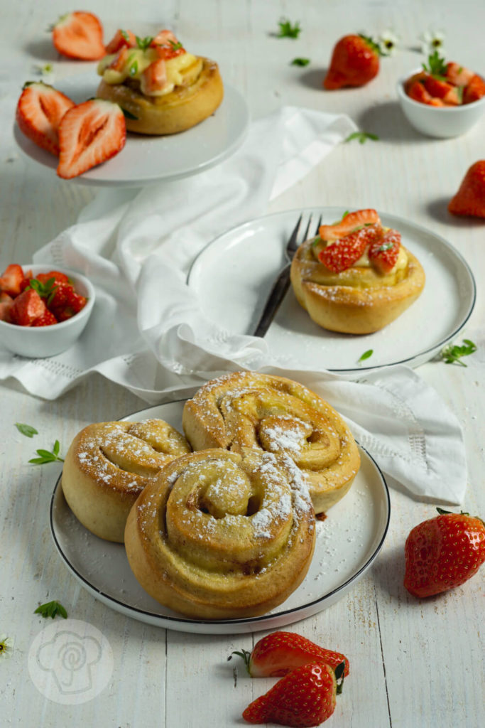 Rezept zum Backen. Fluffige Puddingschnecken aus Hefeteig mit Vanille und Erdbeeren. Dazu ein leckeres Erdbeerragout mit Waldmeister. Perfekt zu Muttertag oder einfach so. Der Teig kann am Vorabend zubereitet werden und dann im Kühlschrank über Nacht gehen. Küchentraum & Purzelbaum