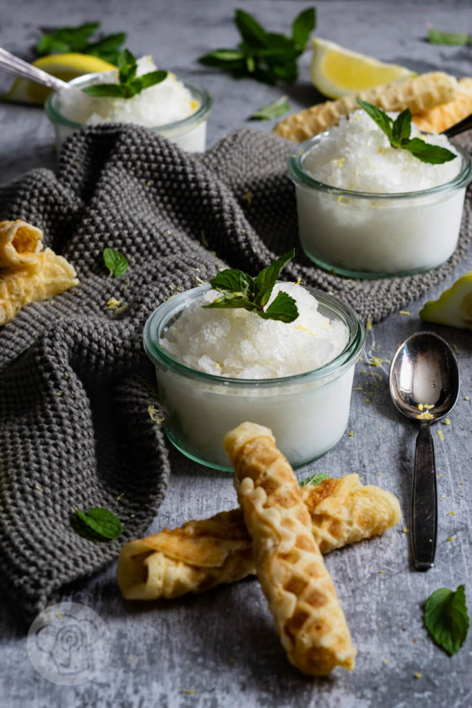 3 Gläser Zitronen Granita mit Zitronenvierteln, Minze und Waffeln