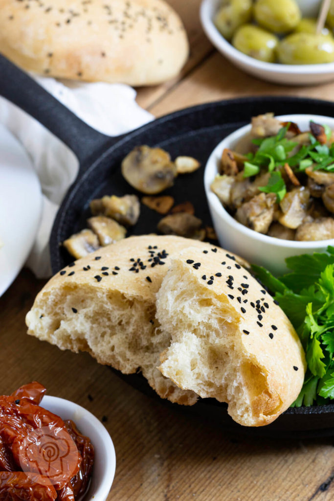 Gebratene Knoblauch Champignons mit Petersilie und Fladenbrot. Tapas serviert in einer gusseisernen Pfanne.