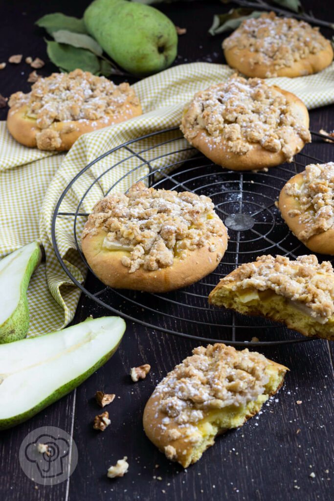 Kleine Streuselkuchen mit Birnen auf einem Rost.