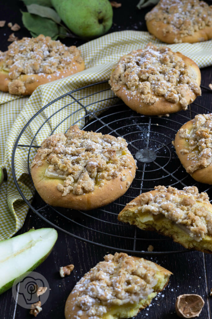 Kleine Streuselkuchen mit Birnen auf einem Rost.