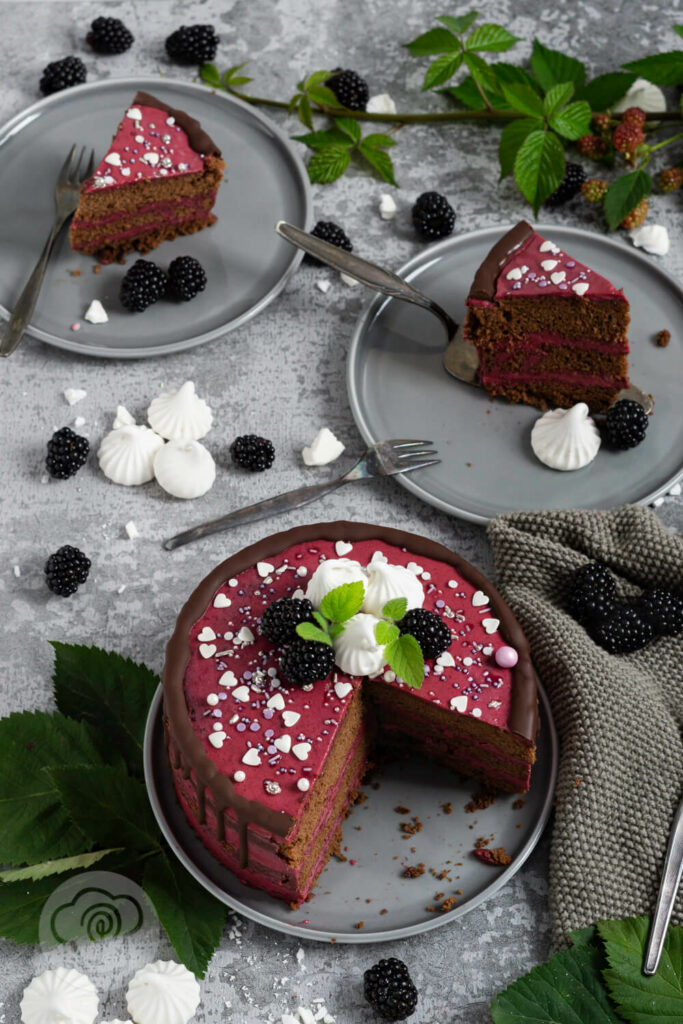 Brombeer Torte mit Schokolade auf einem Teller angeschnitten, mehrere Stücke auf Tellern. Brombeeren als Dekoration.