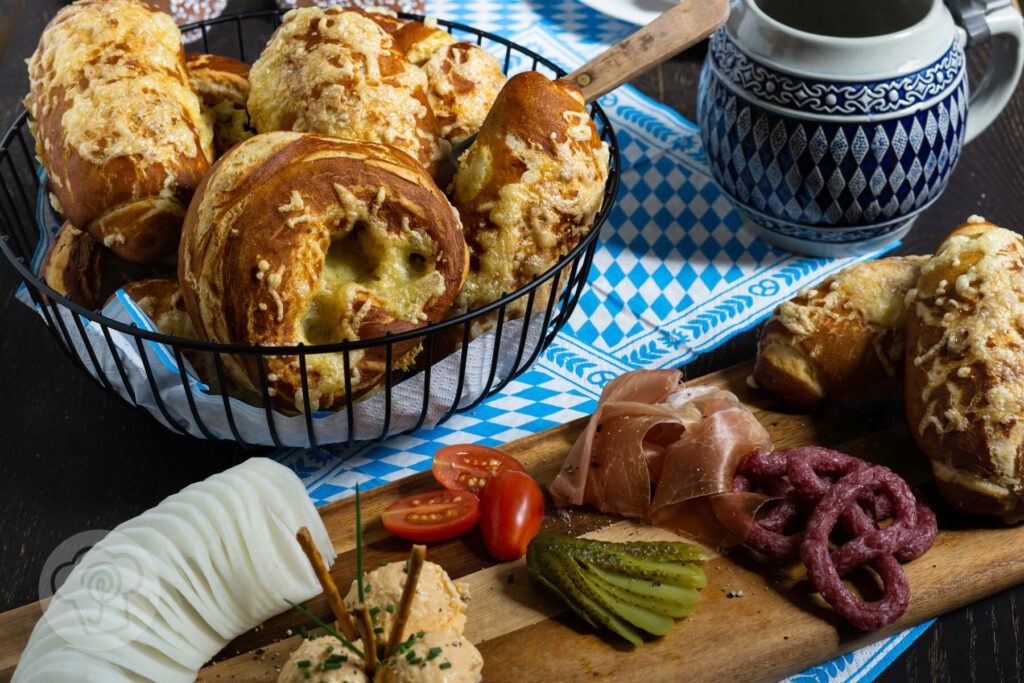 Käse Laugenbrezeln im Brotkorb mit einem Bierkrug und einer Vesperplatte