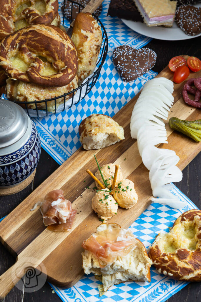 Käse Laugenbrezeln im Brotkorb mit einem Bierkrug und einer Vesperplatte