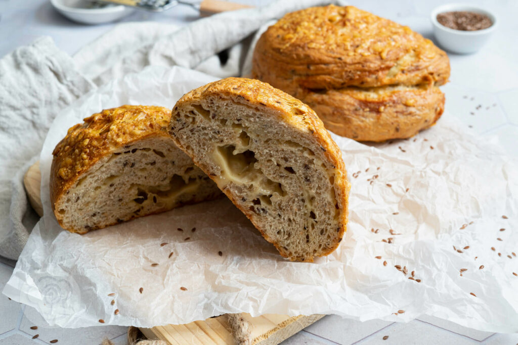 Leinsamen Käse Brot halbiert auf einem Holzbrett