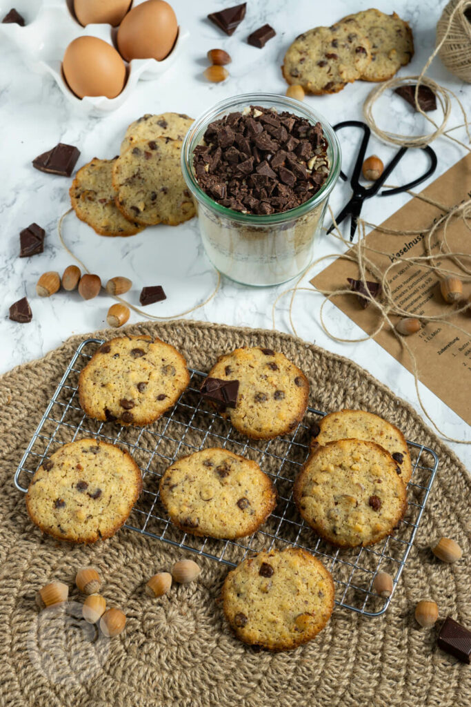 Schoko Cookies mit Nüssen auf einem Rost, dazu die passende Backmischung im Glas