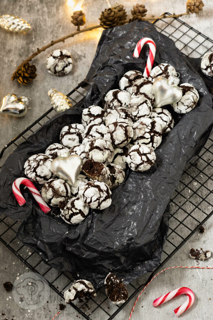 Schoko Crinkle Cookies mit Zuckerstange und Weihnachtsdeko auf einem Rost