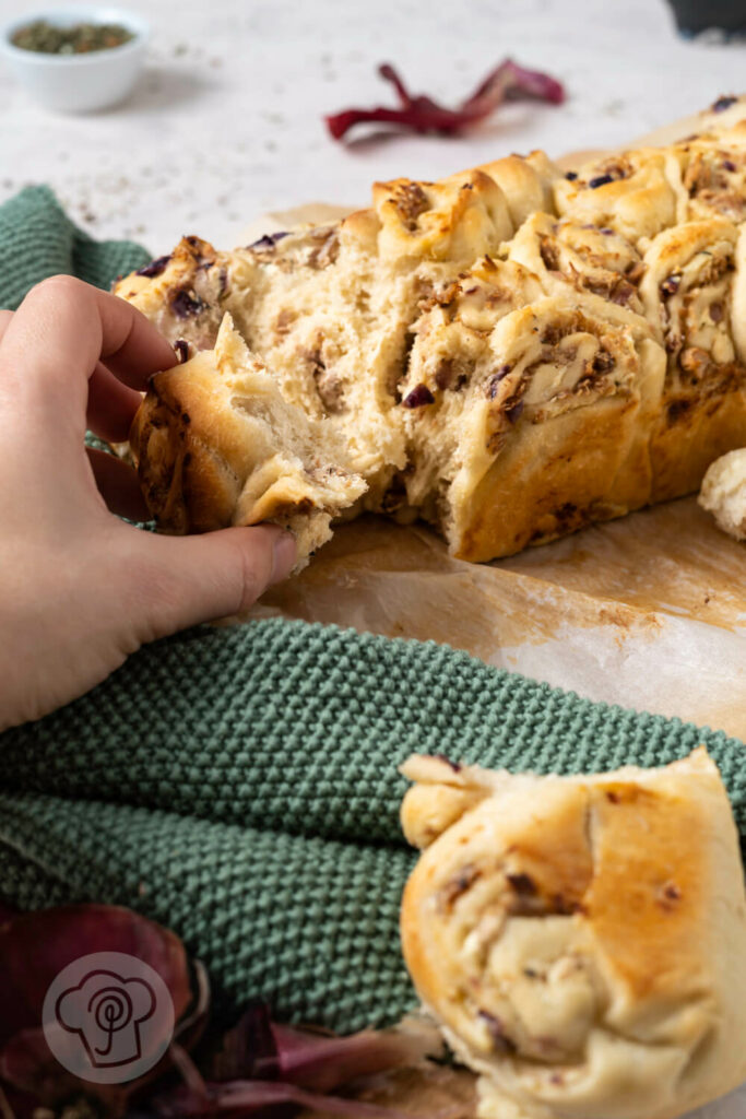 Fingerbrot mit Tunfisch aufgebrochen auf einem Holzbrett.