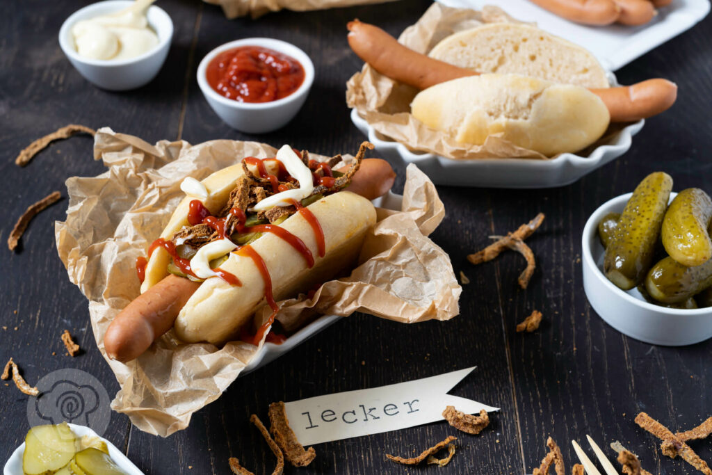 Hot Dog mit Gewürzgurken, Röstzwiebeln, Ketchup und Mayo