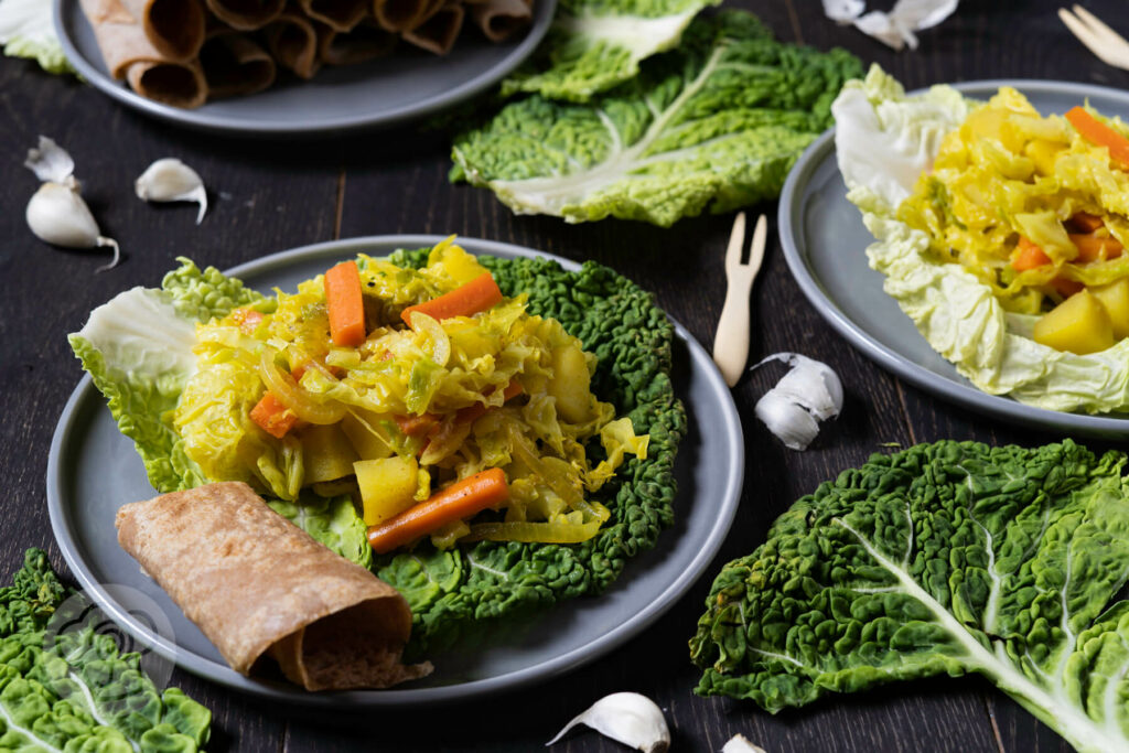 Wirsingeintopf auf einem Wirsingblatt serviert mit Injera