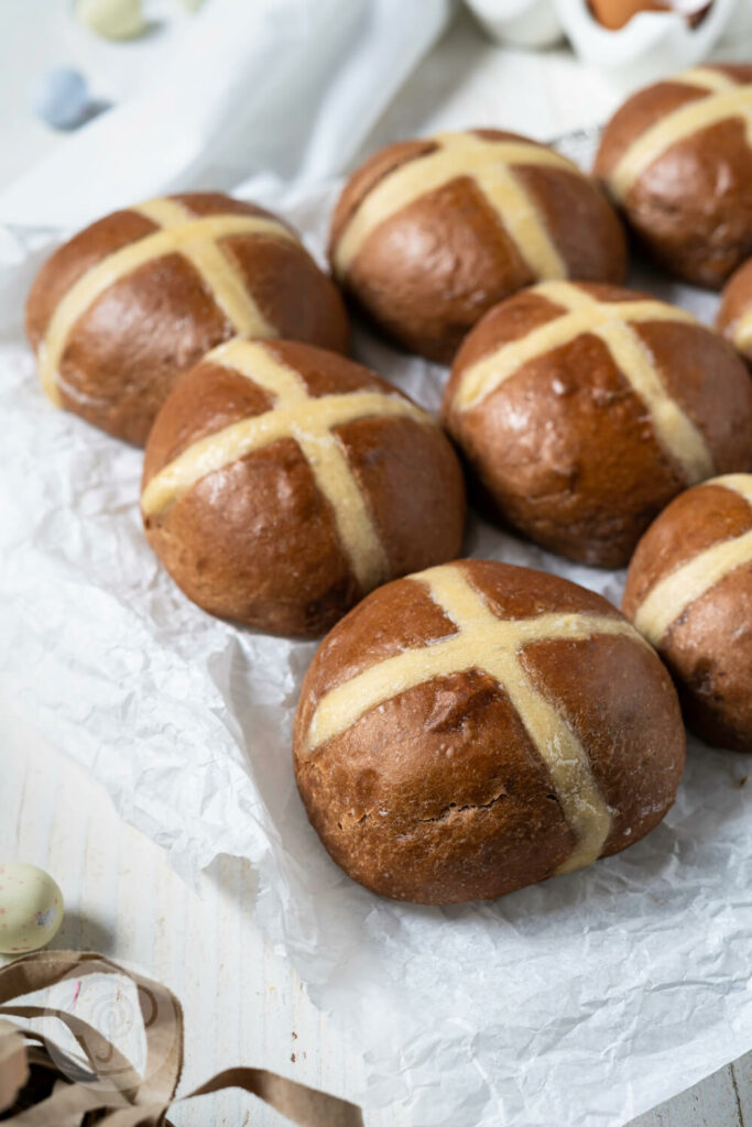 Hot Cross Buns auf einem Rost mit Backpapier.