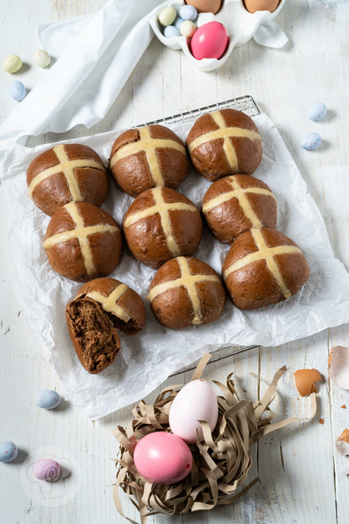 Hot Cross Buns auf einem Rost mit Backpapier.