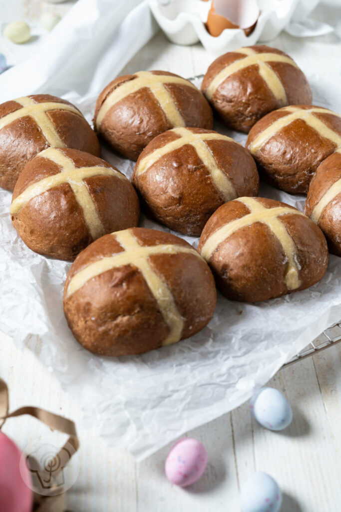 Hot Cross Buns auf einem Rost mit Backpapier.