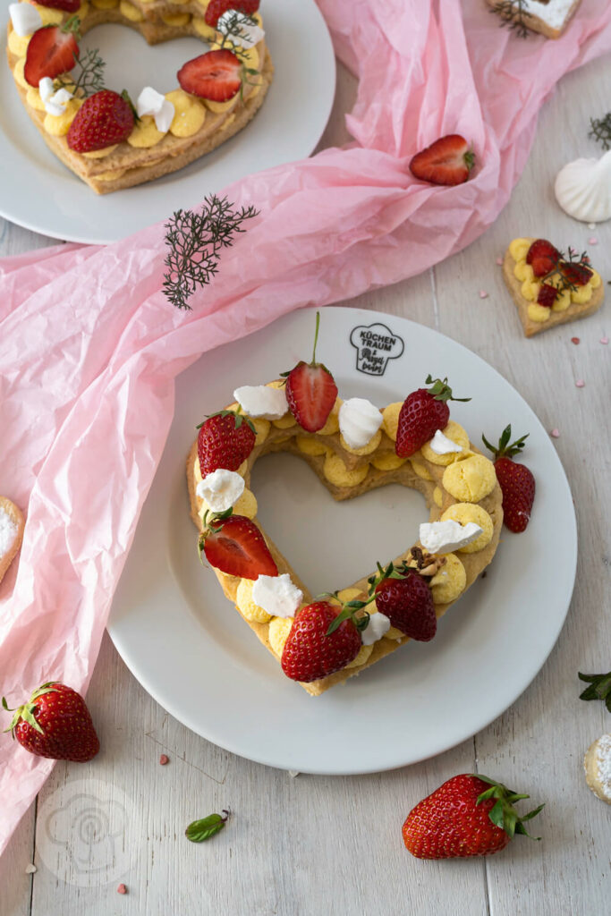 Letter Cakes auf Tellern verteilt mit Erdbeeren und Baiser dekoriert
