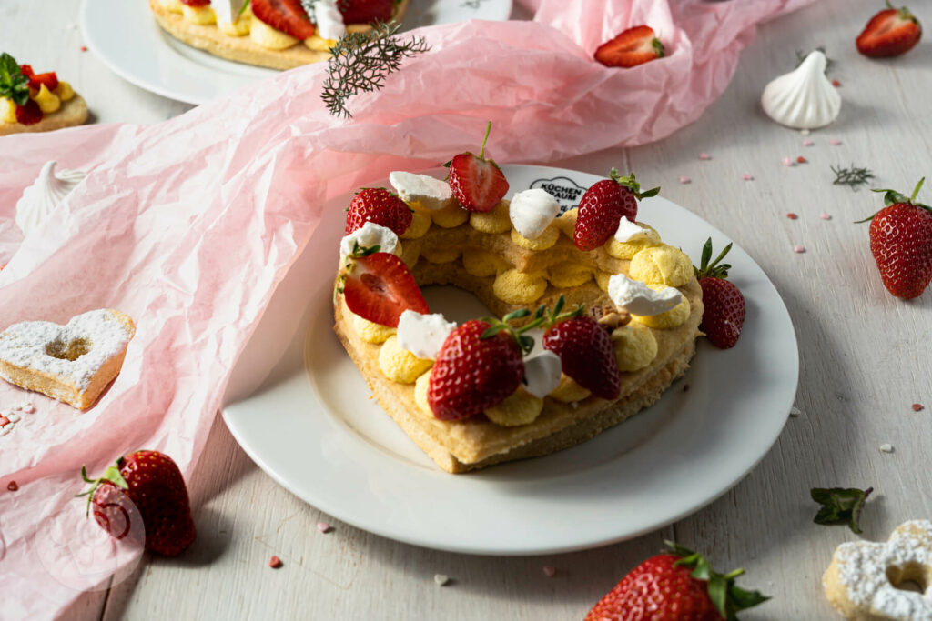 Letter Cakes auf Tellern verteilt mit Erdbeeren und Baiser dekoriert
