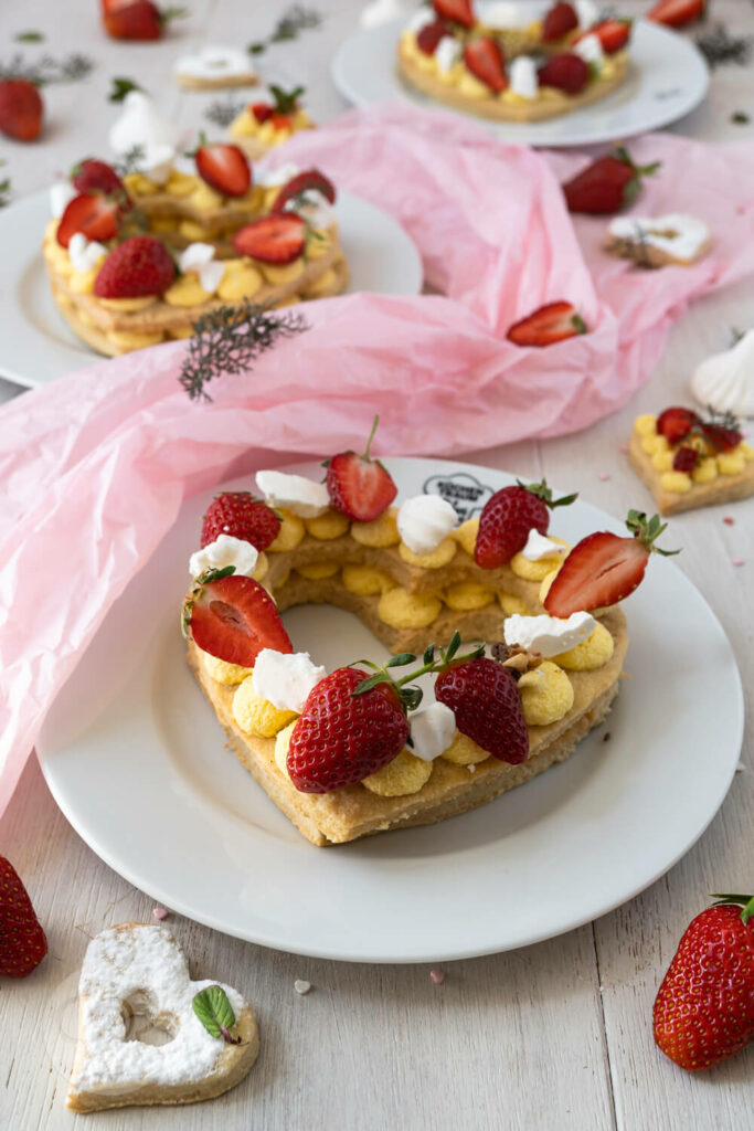 Letter Cakes auf Tellern verteilt mit Erdbeeren und Baiser dekoriert
