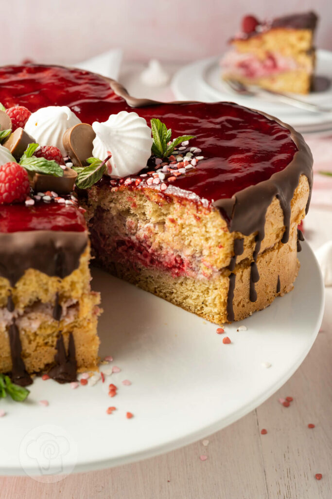 Himbeertorte auf einer Etagère, angeschnitten