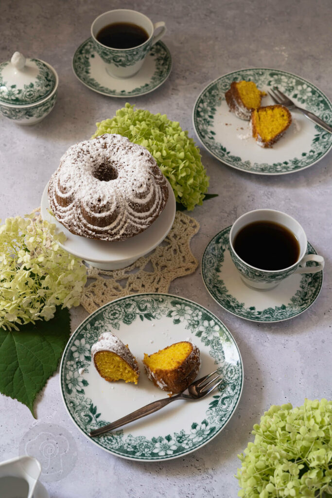 Apfelkuchen mit Safran auf einer Etagère, Kaffeetassen, Kuchenstücke