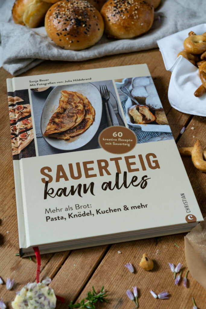 Buch Sauerteig kann alles. Im Hintergrund Brioche Burger Buns