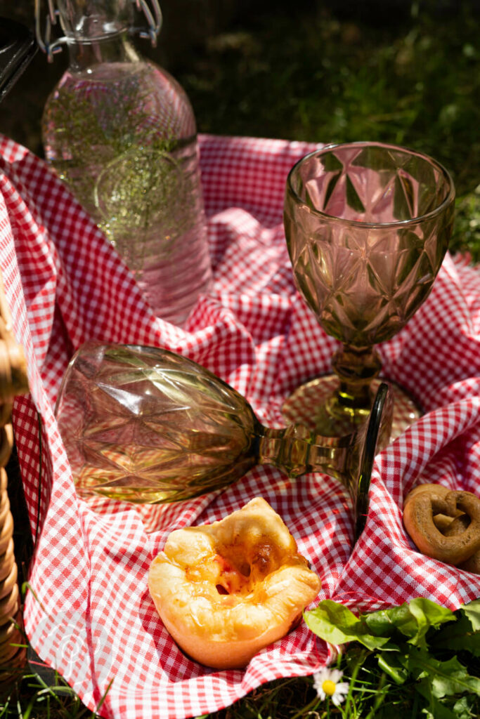 Pizzamuffin auf einer Decke, mit Gläsern & Flasche