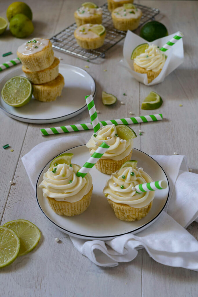 Gin Tonic Cupcakes 2 Gin Tonic Cupcakes mit Strohhalmen und Limetten.