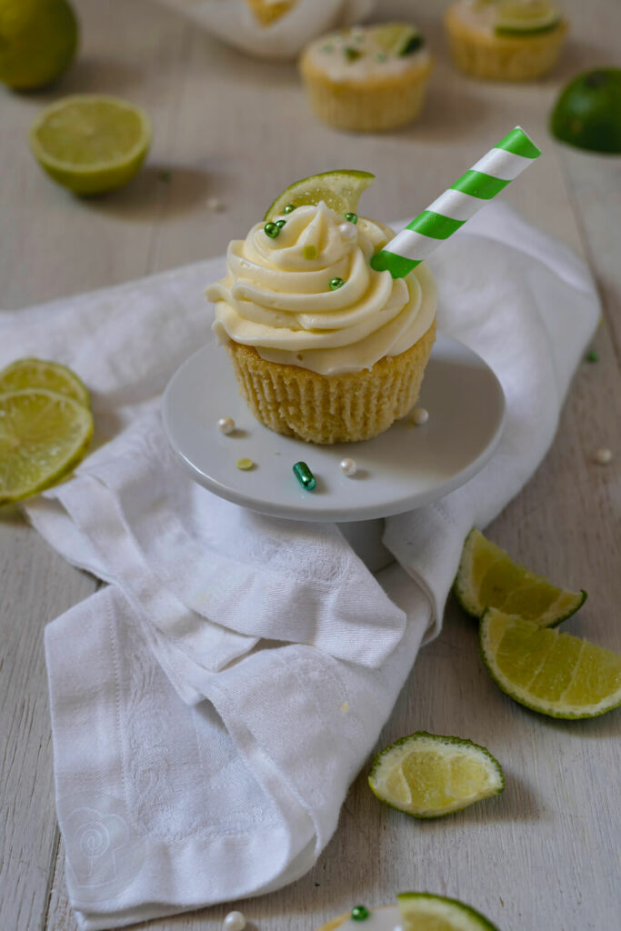 Gin Tonic Cupcake mit Strohhalm und Limetten auf einer Etagère..