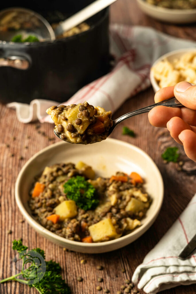 Vegetarischer Linseneintopf im Teller angerichtet