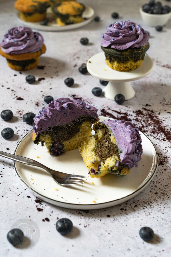 Heidelbeer Muffin mit Frosting auseinandergeschnitten auf einem Teller