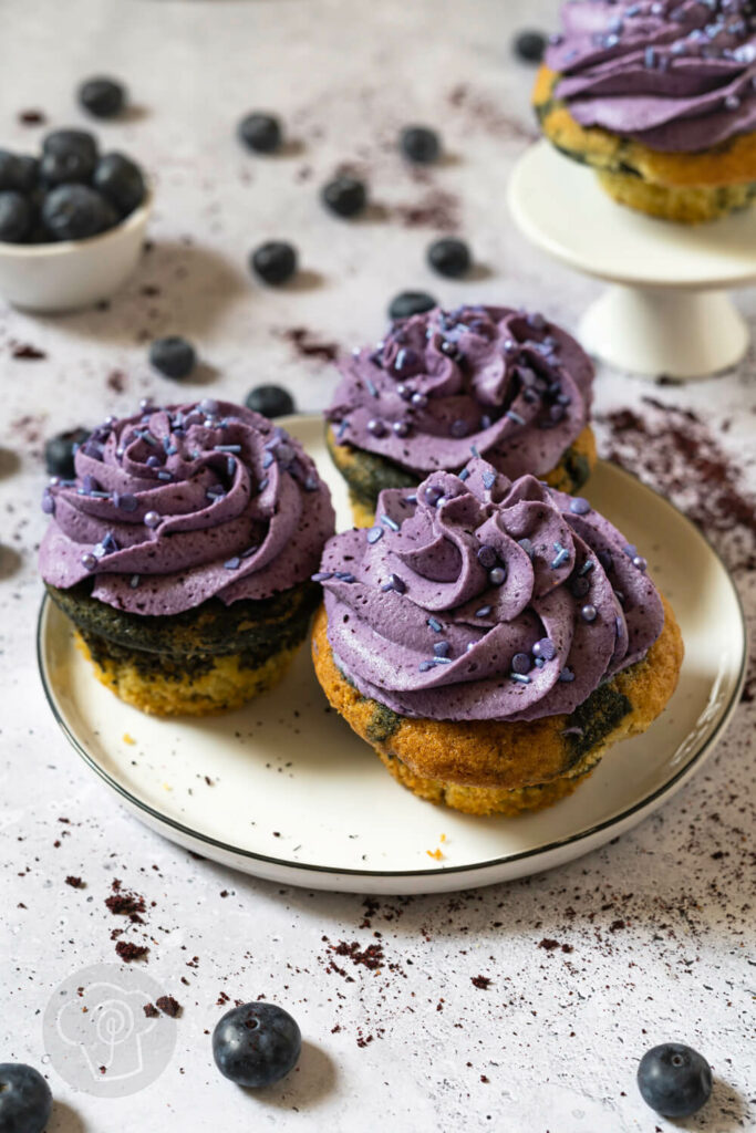 Drei Heidelbeer Cupcakes auf einem Teller