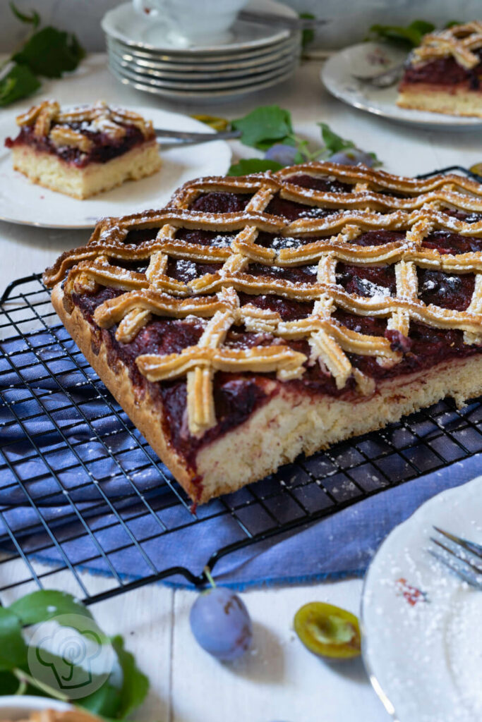 Pflaumenkuchen mit Marzipangitter auf einem Kuchengitter