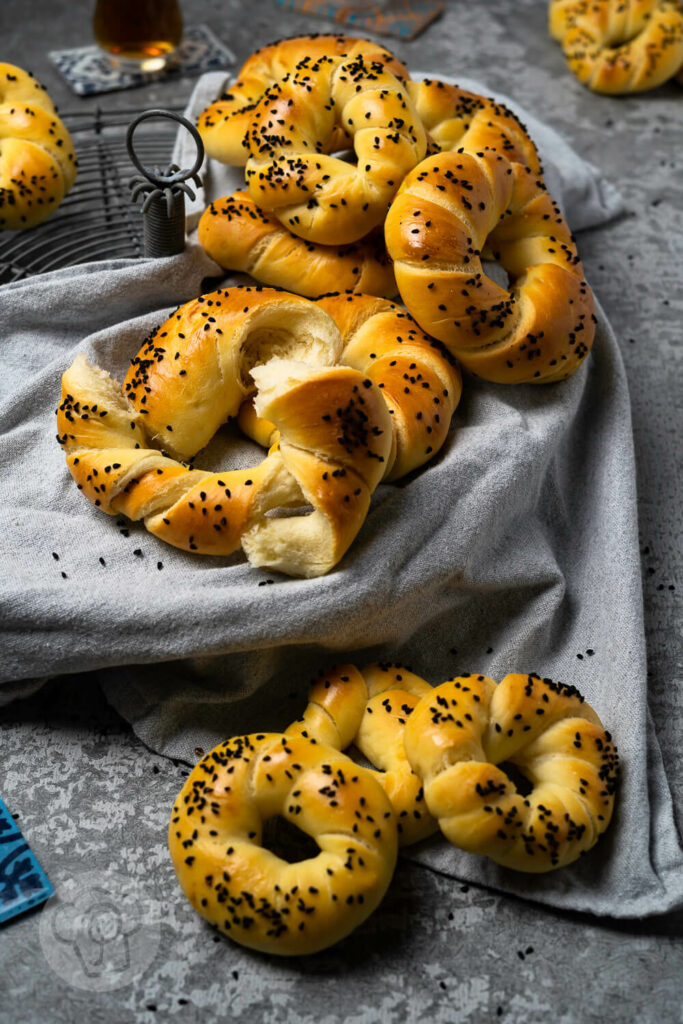 Acma - türkische Brötchen aus Hefeteig auf einem Rost, dazu Tee