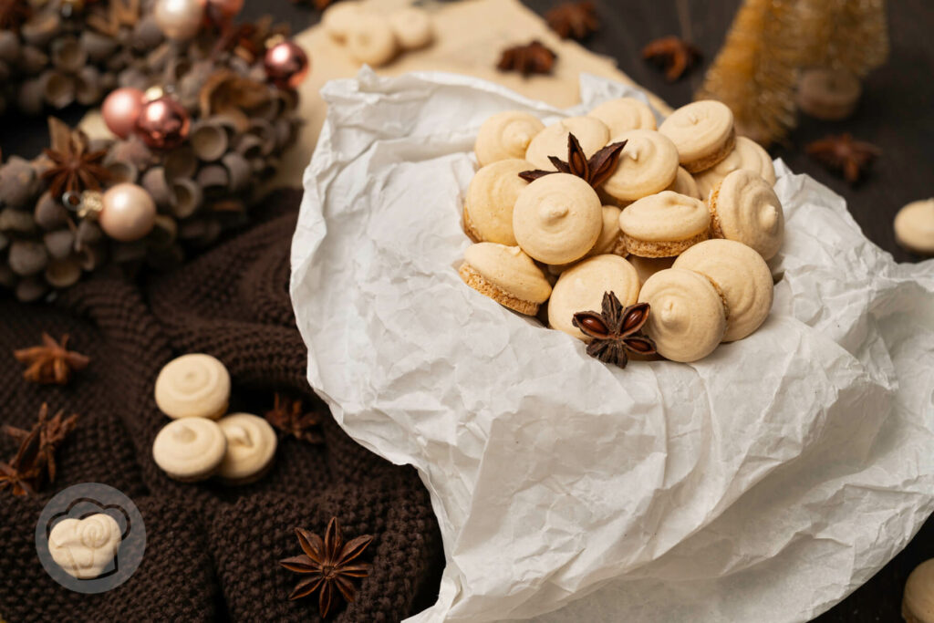 Anisplätzchen in einer Dose, dazu Anissterne, ein Adventskranz und Dekobäume