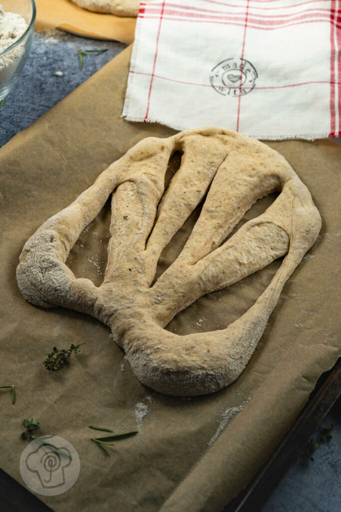 Französische Fougasse auf einem Backblech, ungebacken.