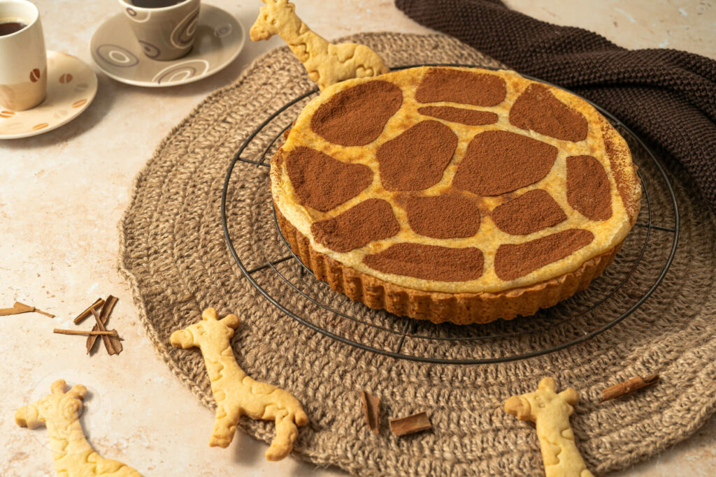 Namibische Milktarte - Melktert auf einem Kuchenrost mit Kaffee und Keksen serviert