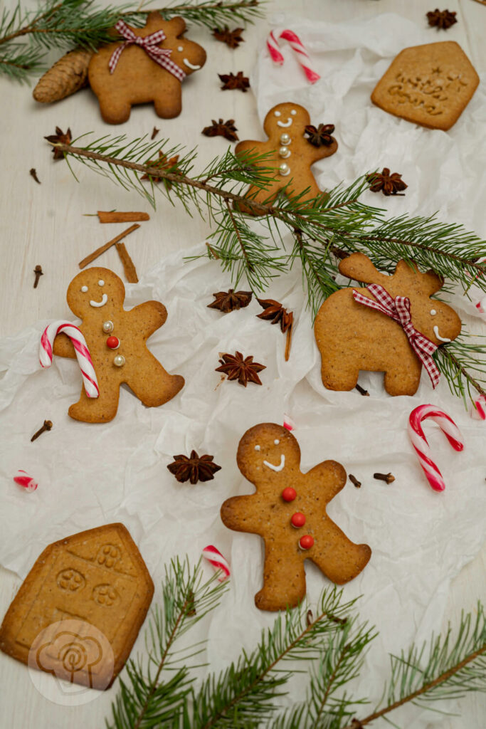 Schwedische Pfefferkuchen auf Seidenpapier mit Zuckerstangen und Gewürzen