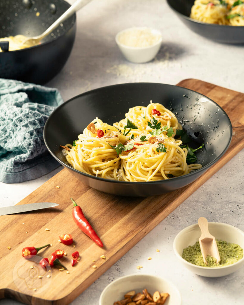 Spaghetti aglio e olio - der italienische Klassiker, auf dem Teller mit Chili, gerösteten Knoblauchscheiben und Petersilie