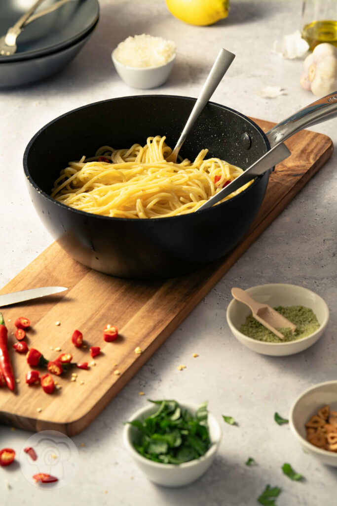 Spaghetti aglio e olio - der italienische Klassiker, in der Pfanne mit Chili, gerösteten Knoblauchscheiben und Petersilie