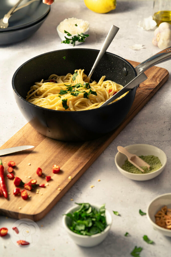 Spaghetti aglio e olio - der italienische Klassiker, in der Pfanne mit Chili, gerösteten Knoblauchscheiben und Petersilie