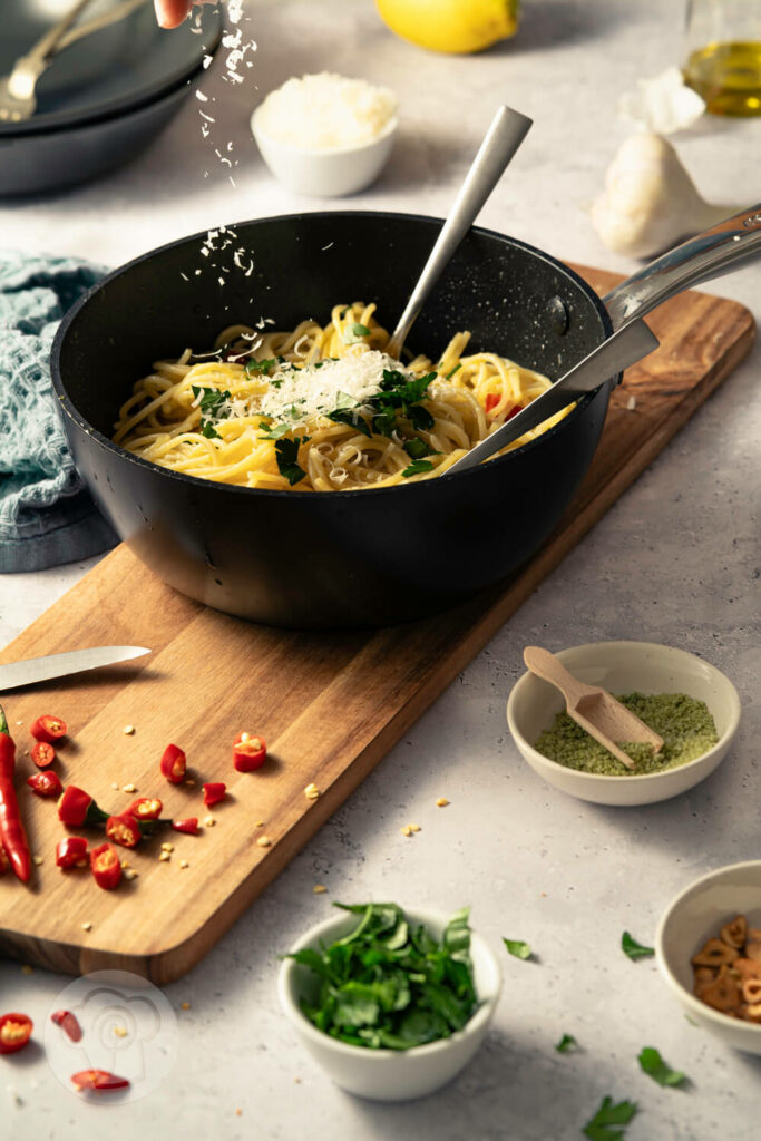 Spaghetti aglio e olio - der italienische Klassiker, in der Pfanne mit Chili, gerösteten Knoblauchscheiben und Petersilie