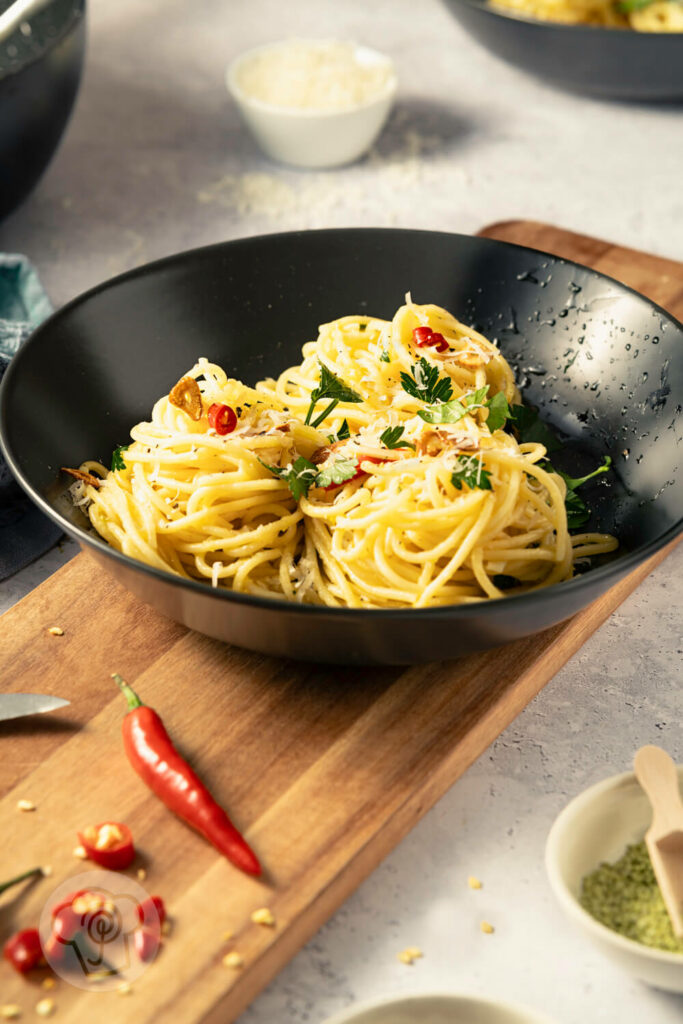 Spaghetti aglio e olio - der italienische Klassiker, auf dem Teller mit Chili, gerösteten Knoblauchscheiben und Petersilie